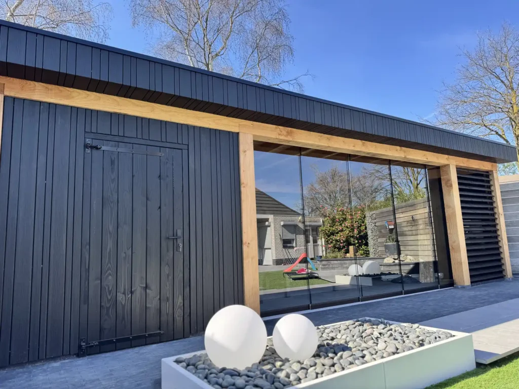 Moderne tuinoverkapping met antraciet houten gevelbekleding, glazen wand en lamellen